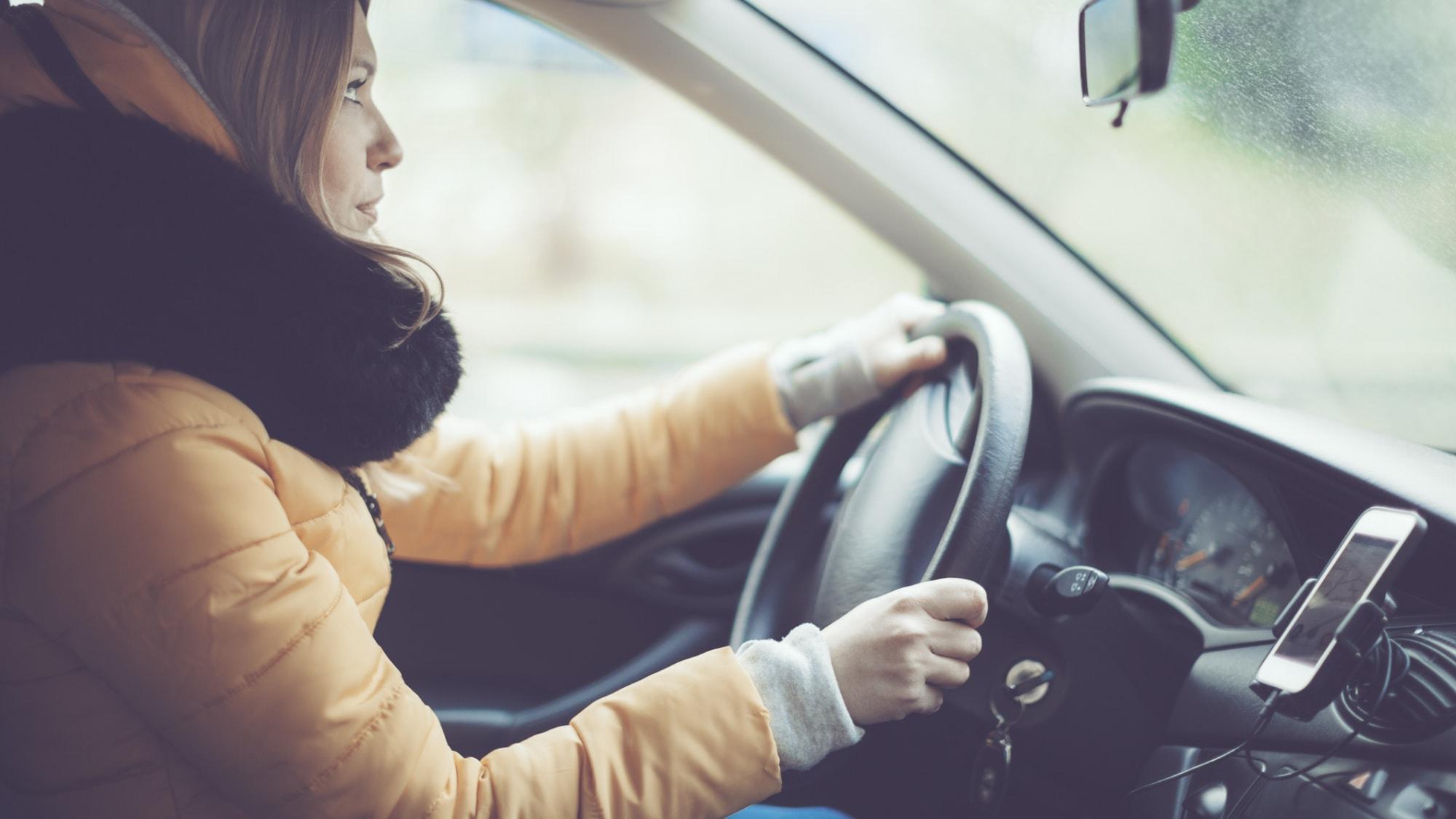 donna con giubbino guida l'auto